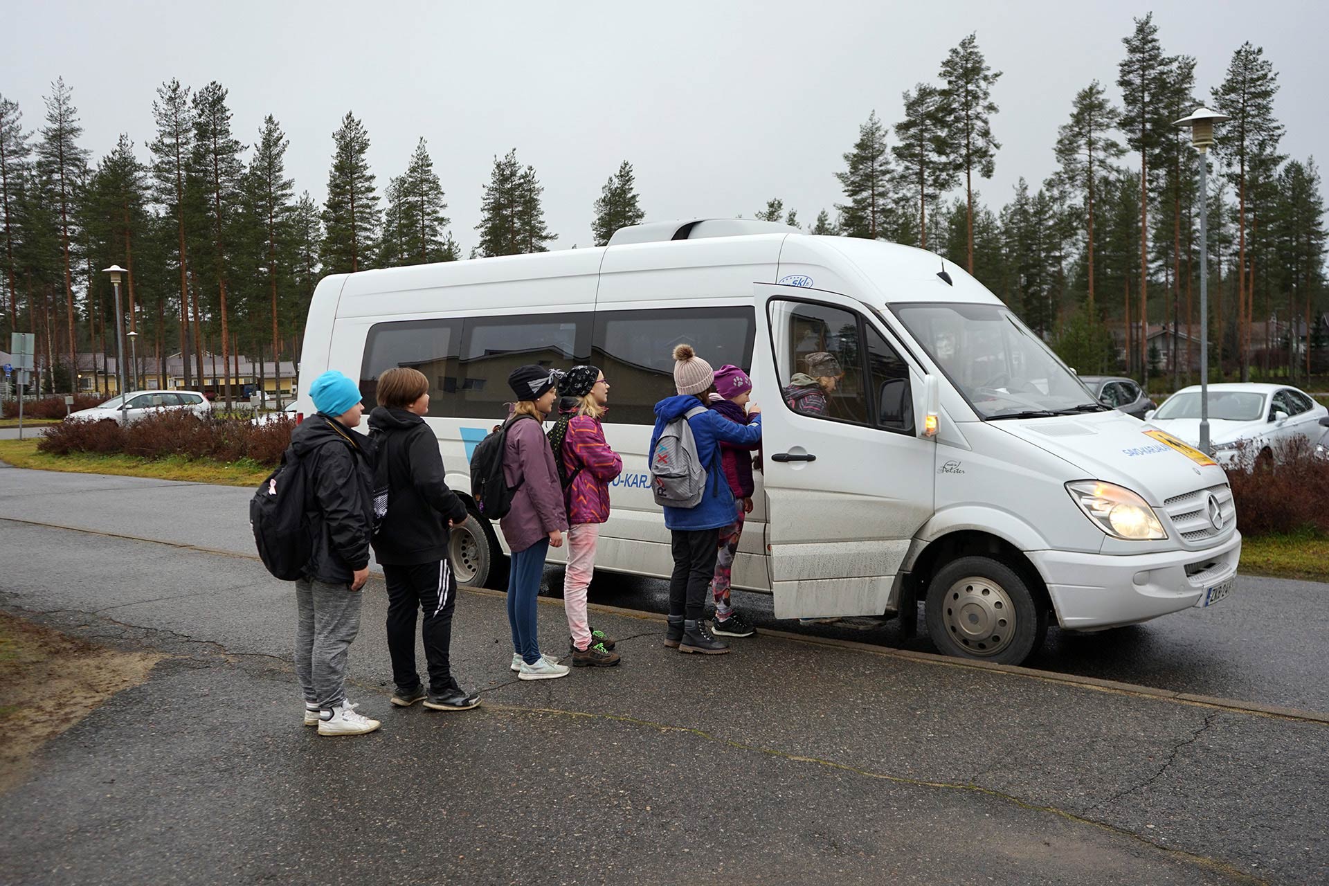 Oppilaat jonottavat koulubussiin.